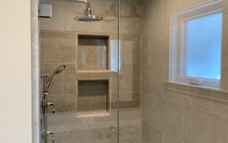 A bathroom with a large glass shower door.