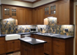 A kitchen with wooden cabinets and black counter tops.