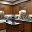 A kitchen with wooden cabinets and black counter tops.