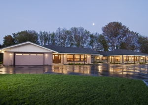 A large house with a driveway and grass in front of it.