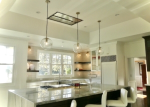 A kitchen with white walls and black counter tops.