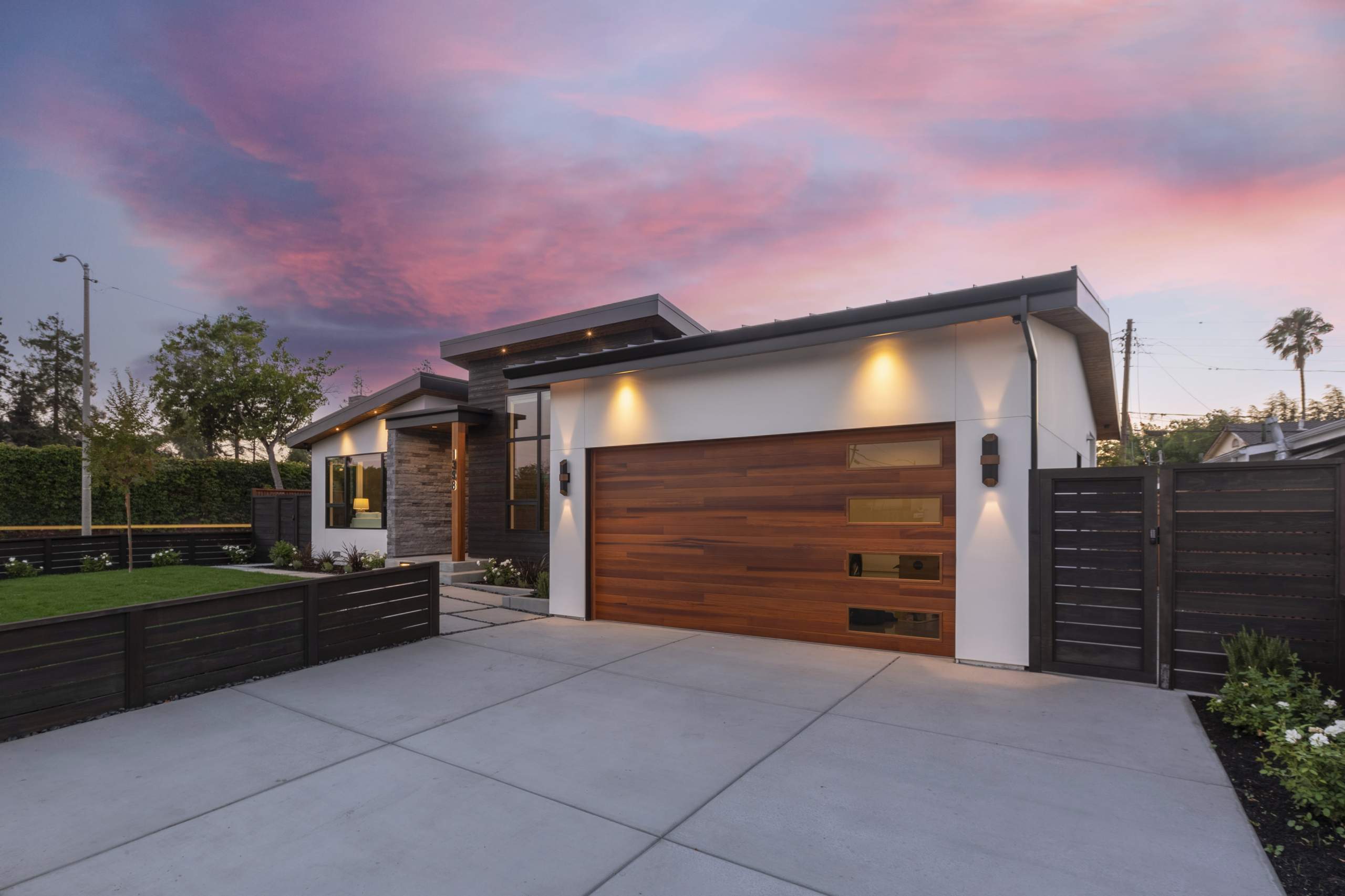 A modern home with wood garage door and white walls.