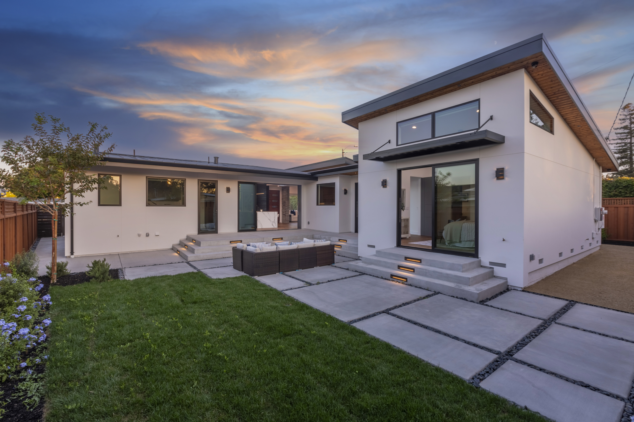 A large backyard with grass and concrete patio.